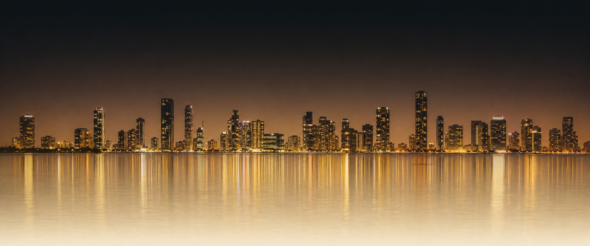 Miami skyline at night, reflected in Biscayne Bay